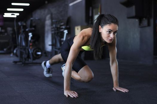 Beautiful muscular fit woman exercising building muscles
