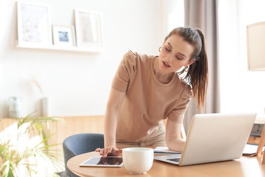 Young business woman standing in her home office reading notes