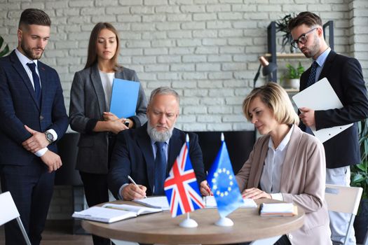Two business partners signing a document. The European Union The United Kingdom