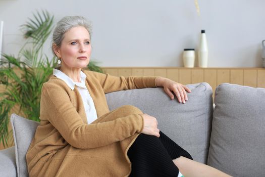Attractive middle aged woman relaxing in sofa at home