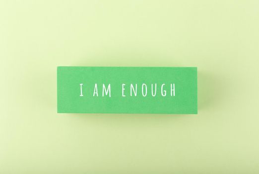I am enough concept on bright pastel green background. Lettering design for positive, motivation quote, mental health, self love and body positive
