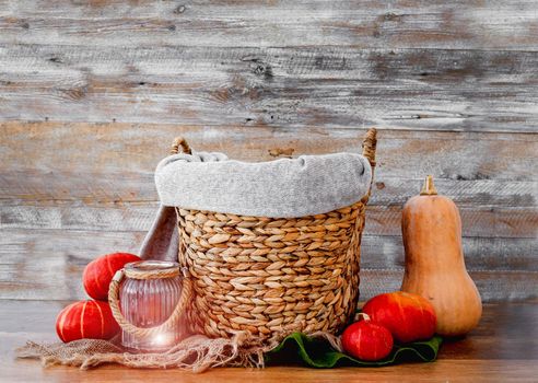Stylized basket for newborn baby photoshoot with autumn veggies pampkin decor on wooden background. Studio handmade scene for infant child halloween photos