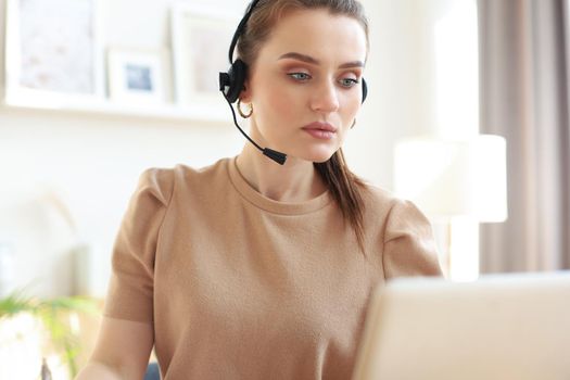 Freelance operator talking with headsets and consulting clients from home office