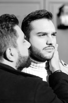 Black and white portrait of european hugging and kissing gays. Concept of love, same sex couple and lgbt.