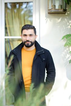 Brunette handsome man standing near window. Concept of male person.