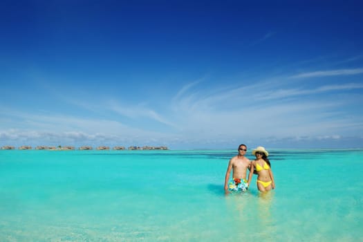 happy young asian couple enjoying summer and have on beautiful white sand beach