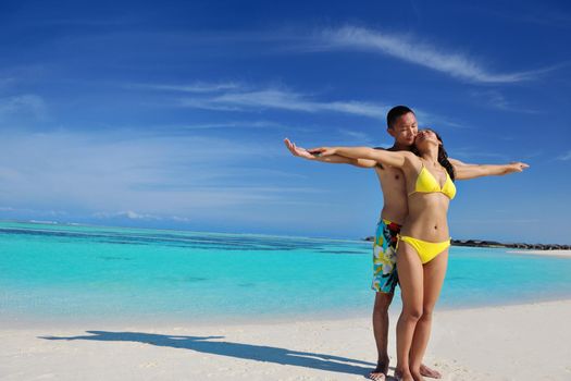 happy young asian couple enjoying summer and have on beautiful white sand beach