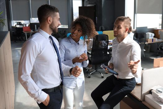 Group of young business people discussing something while working in the creative office.