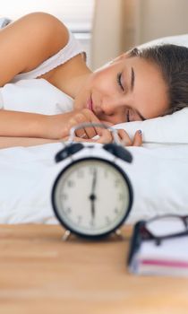 A beautiful young woman lying in bed comfortably and blissfully.