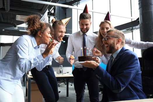 Business team celebrating a birthday of collegue in the modern office.