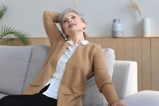 Attractive middle aged woman relaxing in sofa at home