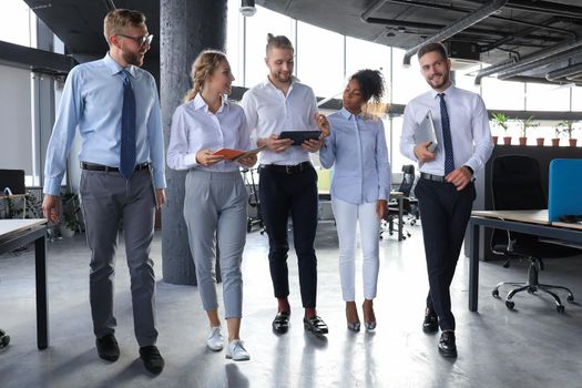 Modern business people have a discussion while walking through the office.