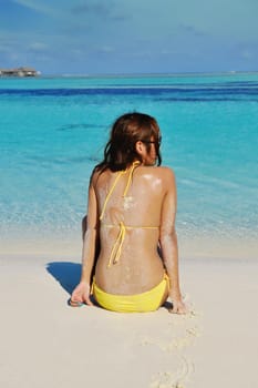 happy young pretty asian woman resting on sand at beach