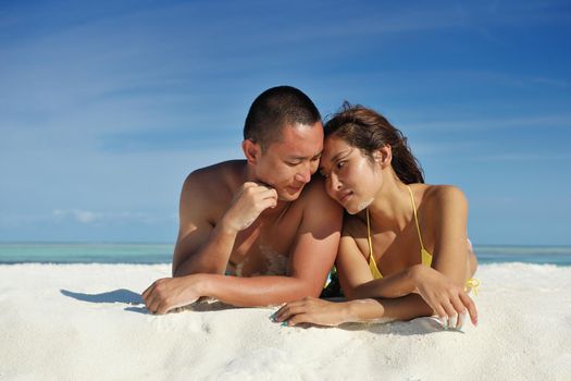 happy young asian couple enjoying summer and have on beautiful white sand beach