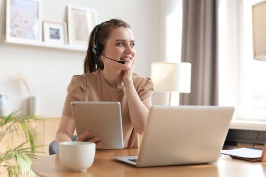 Freelance operator talking with headsets and consulting clients from home office