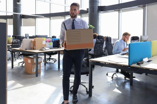 Dismissed worker going from the office with his office supplies.