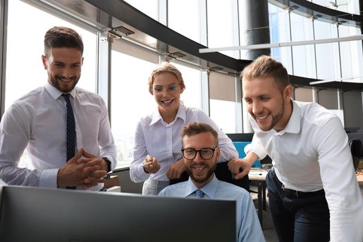 Group of young modern people in formalwear using modern technologies while working in the creative office.