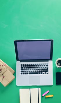 Notebook with gifts and laptop on wooden table
