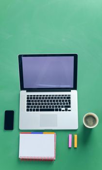 Office desk table with laptop, smart phone, photocamera