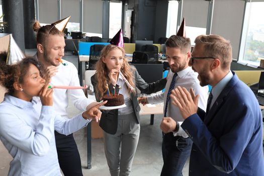 Business team celebrating a birthday of collegue in the modern office.