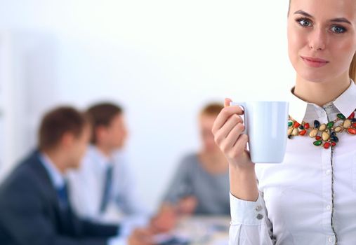 Portrait of a young woman working at office standing .