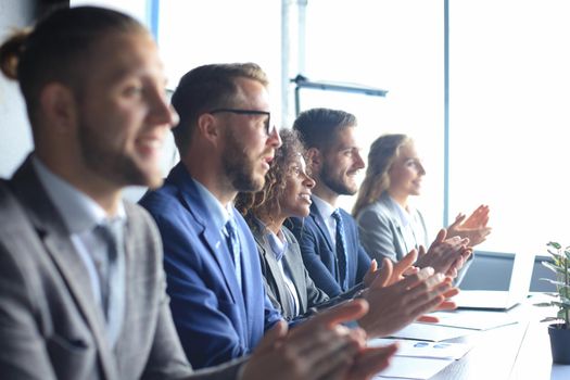 Photo of happy business people applauding at conference