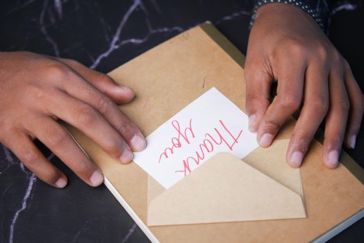 close up of man hand reading a thank you letter .