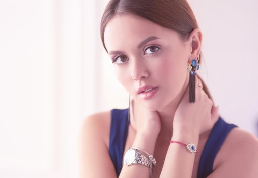 Young woman sitting on a chair isolated over white background.