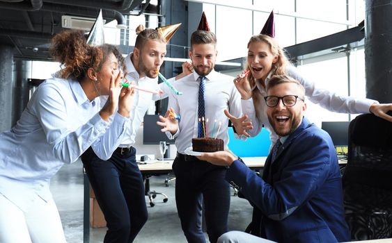 Business team celebrating a birthday of collegue in the modern office.