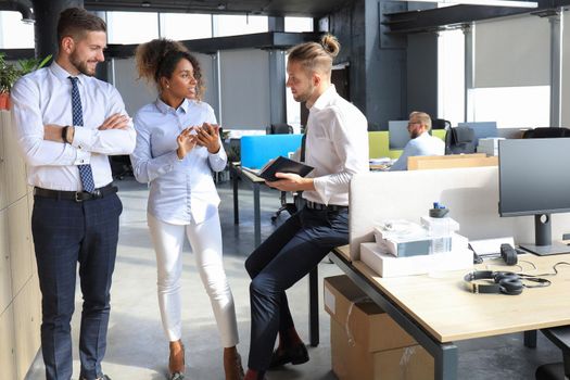 Group of young business people discussing something while working in the creative office.