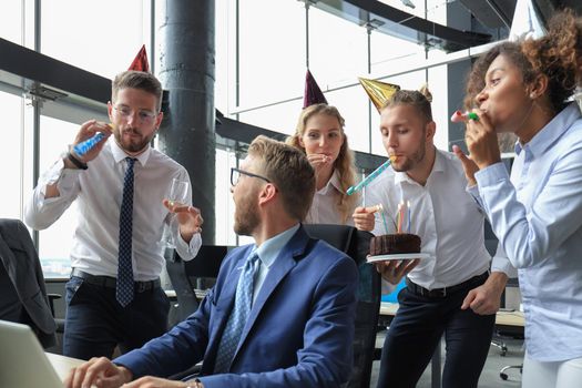 Business team celebrating a birthday of collegue in the modern office.