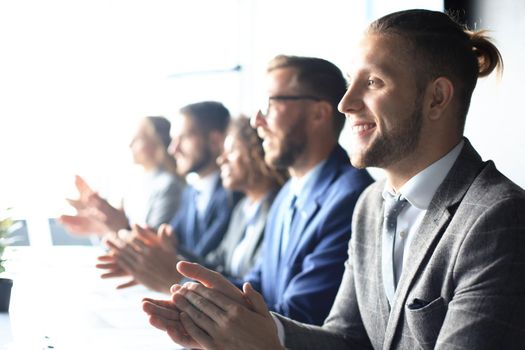 Photo of happy business people applauding at conference