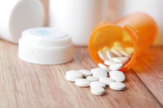 white color medical pills spilling on pink ,