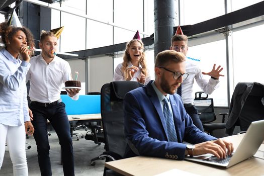 Business team celebrating a birthday of collegue in the modern office.