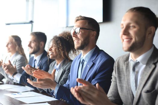 Photo of happy business people applauding at conference