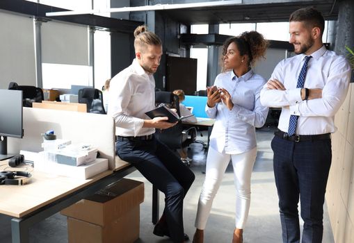 Group of young business people discussing something while working in the creative office.