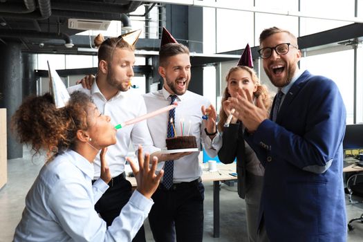 Business team celebrating a birthday of collegue in the modern office.