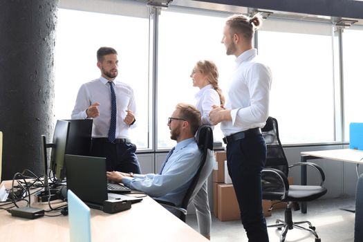 Group of young business people discussing something while working in the creative office.