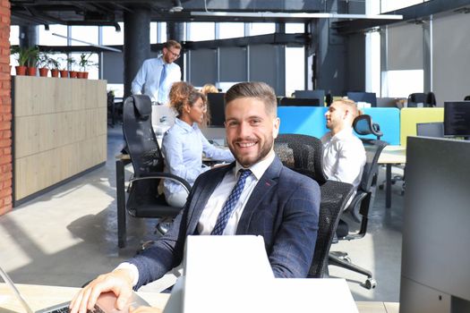 Businessman with colleagues in the background in modern office.