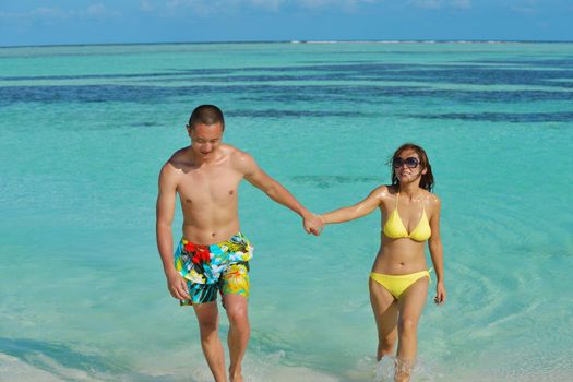 happy young asian couple enjoying summer and have on beautiful white sand beach