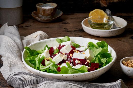 Healthy salad with beet, curd, feta and pine nuts, lettuce. Low carb keto ketogenic dash diet. Dark food photography. Side view