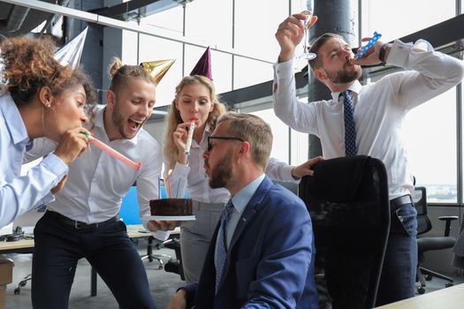 Business team celebrating a birthday of collegue in the modern office.