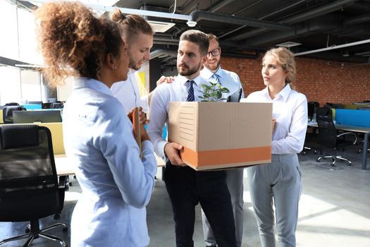 Business colleagues say goodbye to the dismissed employee.