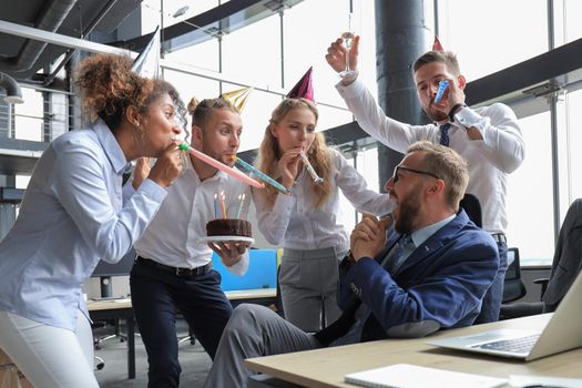 Business team celebrating a birthday of collegue in the modern office.
