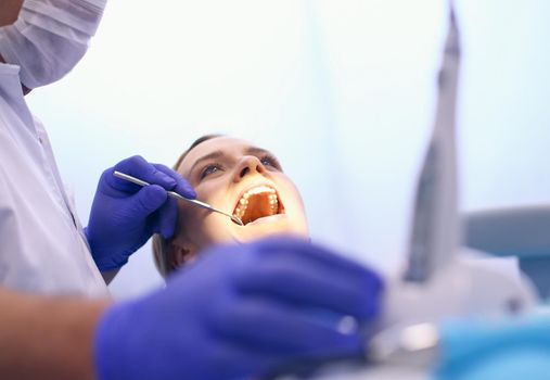 Detail of hand holding dental tools in dental clinic. Dentist Concept.