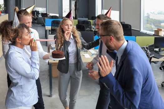 Business team celebrating a birthday of collegue in the modern office.