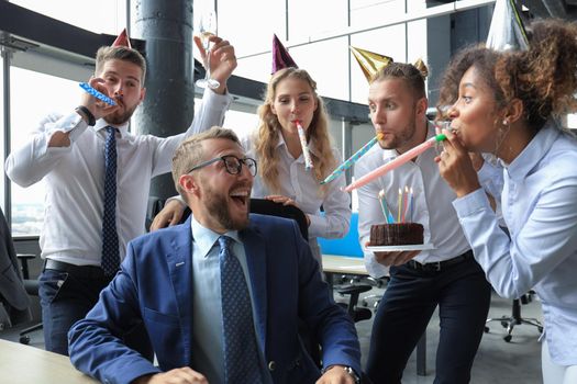 Business team celebrating a birthday of collegue in the modern office.