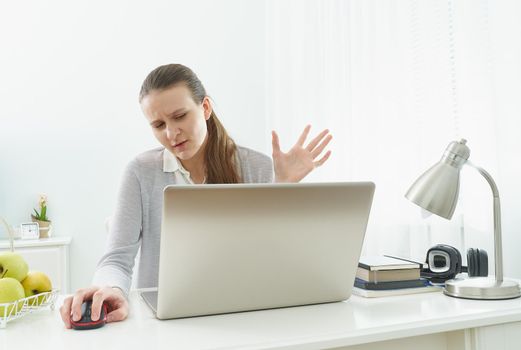 Girl listens or looks at information on computer with disbelief. Skeptical expression on his face. Fake news. Distance education for students. Quarantine, self-isolation, sociophobia.