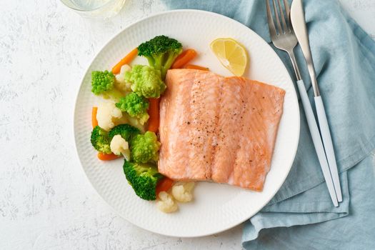Steam salmon and vegetables, Paleo, keto, fodmap, dash diet. Mediterranean diet with steamed fish. Healthy concept, white plate on gray table, gluten free, lectine free, top view