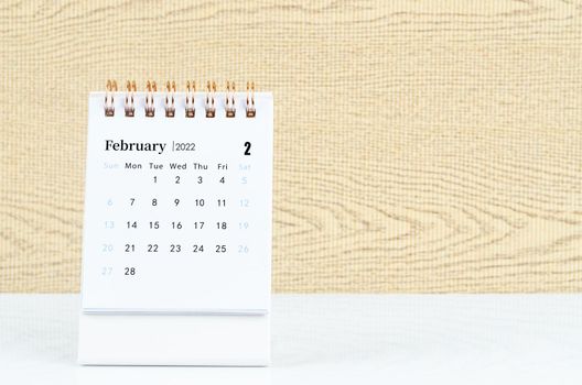The february 2022 desk calendar on white table.